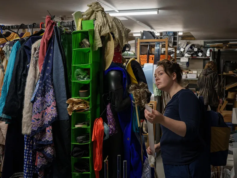 A visitor browsing the costume and clothing rails inside the Scrapstore