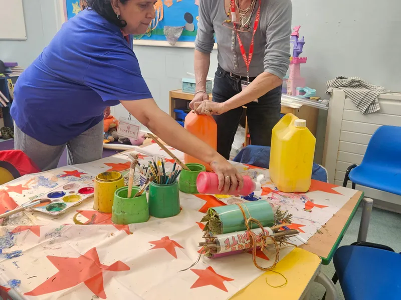 Makers absorbed in their work at a craft table in the Scrapstore