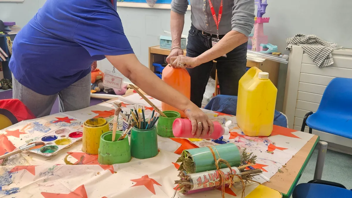 Makers absorbed in their work at a craft table in the Scrapstore