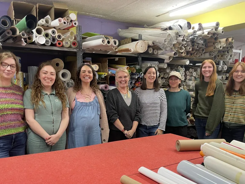 Eight volunteers from a publishing company sorting materials on a corporate volunteering day at the store.