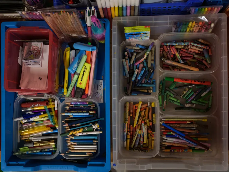 Trays of donated pencils, pens and crayons sorted by type