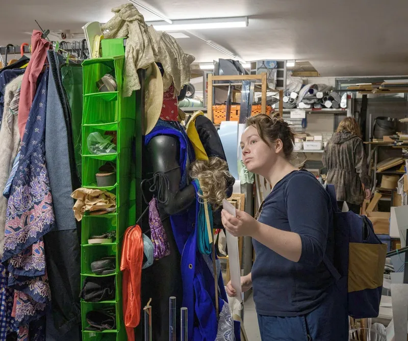 A visitor browsing the costume and clothing rails inside the Scrapstore