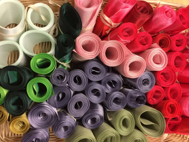Rolls of donated ribbon sorted by colour in a basket