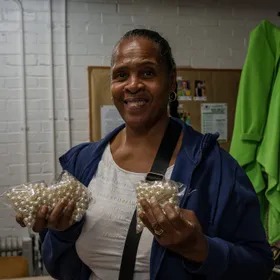 A volunteer holding up bags of donated pearl beads