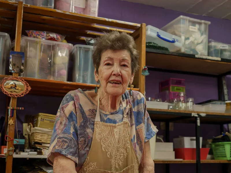 A volunteer in an apron smiling at the store counter